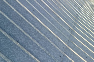 Bükülmüş metal çatının yakın plan görüntüsü dokuyu ve ışık yansımalarını vurguluyor