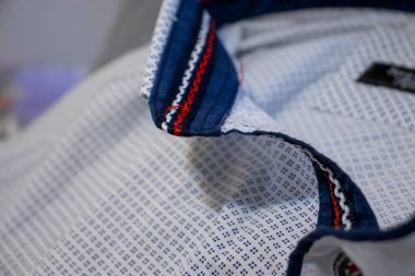 Yakanın detaylarını ve dikişlerini vurgulayan desenli gömlek kumaşının yakın çekimi. Moda tekstil ve giyim konseptleri için ideal.