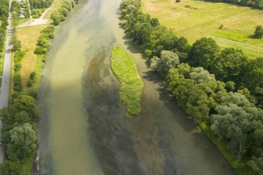 Bereketli yeşilliklerle çevrili sakin bir nehrin havadan görünüşü su ve doğa arasındaki uyumu gösteriyor. Çevresel temalar için mükemmel.