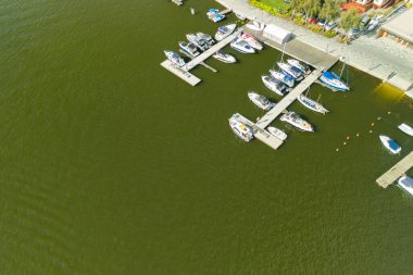Mikolajki 'deki bir marinanın havadan görüntüsü birkaç tekne ve sakin liman manzarası gösteriyor..