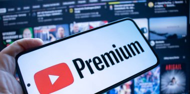 Varşova Polonya - 20 Eylül 2024: YouTube Premium logosunu videoların bulanık arka planında gösteren bir akıllı telefon. Dijital içerik abonelik hizmetleri yükselişte.