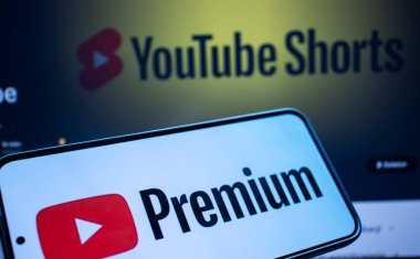 Varşova Polonya - 20 Eylül 2024: YouTube Premium logosunu YouTube Shorts 'un bir zemininde gösteren bir akıllı telefon. Modern dijital medya tüketimi en iyisi..