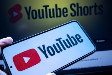Varşova Polonya - 20 Eylül 2024: YouTube logosunu YouTube Shorts 'un bulanık arka planıyla gösteren bir akıllı telefonun yakın çekimi. Dijital içerik yaratıcıları ve pazarlamacılar için ideal.