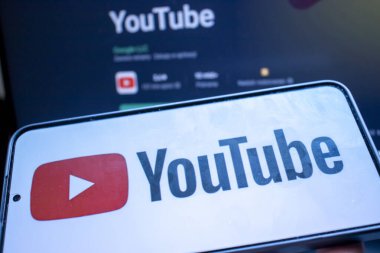 Varşova Polonya - 20 Eylül 2024: YouTube logosu ve arayüzünü karanlık bir arkaplanda gösteren bir akıllı telefonun yakın çekimi. Popüler video paylaşım platformu gösteriliyor.