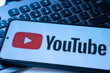 Varşova Polonya - 20 Eylül 2024: YouTube logosunu dijital medya kavramları için ideal bir klavye zemininde gösteren akıllı telefonun yakın çekimi.