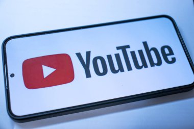 Varşova Polonya - 20 Eylül 2024: YouTube logosunu dijital medya ve çevrimiçi içerik paylaşımını sembolize eden parlak bir arkaplanda gösteren bir akıllı telefon.