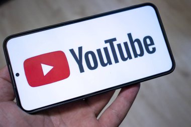 Varşova Polonya - 20 Eylül 2024: Sosyal medya ve dijital içerik oluşturulmasını sembolize eden YouTube logosunu gösteren bir akıllı telefonun yakın çekimi.