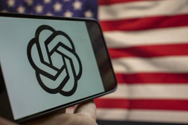 Varşova Polonya - 20 Eylül 2024: OpenAI logosunu teknoloji ve yeniliği sembolize eden Amerikan bayrağının zemininde gösteren bir akıllı telefonun yakın çekimi.