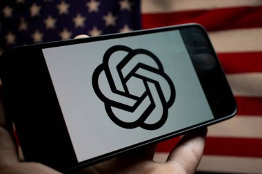 Varşova Polonya - 20 Eylül 2024: OpenAI logosunu yenilik ve teknolojiyi sembolize eden Amerikan bayrağının zemininde gösteren akıllı telefonun yakın çekimi.