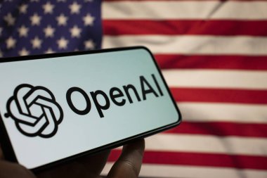 Varşova Polonya - 20 Eylül 2024: OpenAI logosunu Amerikan bayrağının ışıklandırma teknolojisi ve yenilikçiliğinin arka planında gösteren bir akıllı telefonun yakın çekimi.