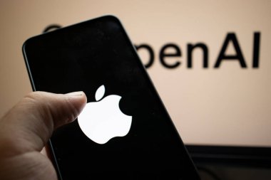 Varşova Polonya - 20 Eylül 2024: Arka planda OpenAI logosu olan bir Apple akıllı telefonu tutan kişi teknoloji entegrasyonunu ve modern yaşam tarzını gösteriyor.