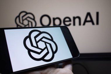 Varşova Polonya - 20 Eylül 2024: OpenAI logosunu markalı bir arkaplan önünde gösteren bir akıllı telefon. Bu görüntü yapay zeka teknolojisindeki yeniliği temsil ediyor..