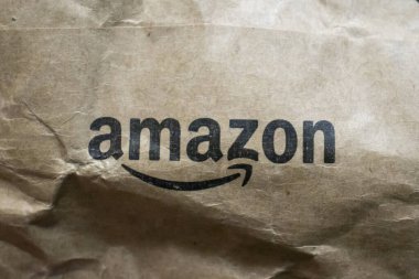 Varşova Polonya - 20 Eylül 2024: Çevrimiçi alışveriş ve kolaylığı sembolize eden Amazon logosu ile buruşmuş kahverengi kağıt ambalajının yakın çekimi.