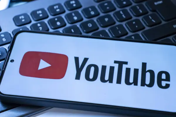 Varşova Polonya - 20 Eylül 2024: YouTube logosunu dijital medya kavramları için ideal bir klavye zemininde gösteren akıllı telefonun yakın çekimi.