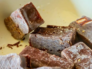 Çikolatanın dokusunu ve zenginliğini vurgulayan tarafsız bir arkaplanda çekilmiş lezzetli çikolata parçalarının yakın çekimi. Gıda projeleri için mükemmel..