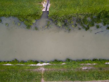 Bereketli yeşilliklerle çevrili sakin bir nehrin havadan görünüşü doğanın güzelliğini ve sükunetini gözler önüne seriyor..