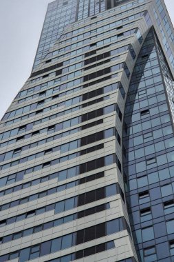 Modern bir ofis binasında cam ve dinamik mimari sergileniyor. Bu şehir yapısı şehir yaşamındaki yenilikleri ve çağdaş tasarımı yansıtır..