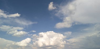 Tüylü beyaz bulutları olan güzel mavi bir gökyüzü doğa severler ve fotoğraf meraklıları için mükemmeldir.