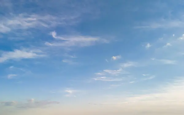 A serene blue sky with fluffy clouds perfect for conveying a sense of calm and tranquility. Ideal for backgrounds or nature themes.