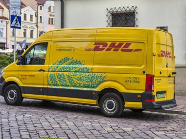 Rzeszow, Poland - October 15, 2024: A DHL delivery van parked in the street, showcasing its environmentally friendly electric drive. Ideal for logistics and transportation themes. clipart