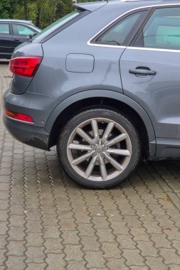 Rzeszow Polonya - 20 Eylül 2024: Parke taşlı bir sokakta lüks bir araba lastiğinin yakın çekimi modern otomotiv tasarımı ve zarafeti canlı bir açık hava ortamında sergileniyor.