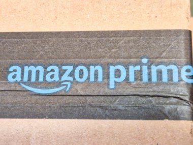 Varşova, Polonya - 20 Eylül 2024: Bir Amazon Prime paketi, marka logosu ve ambalaj tasarımı vurgulanıyor. E-ticaret ve nakliye temaları için ideal.