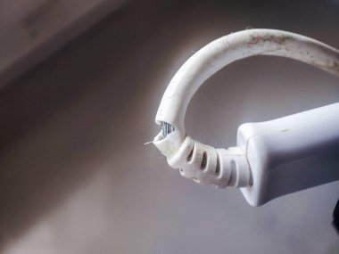 Hasarlı bir elektrik kablosunun yakın plan görüntüsü açığa çıkan kabloları gösteriyor ve günlük hayatta elektrik güvenliği ve bakımının önemini vurguluyor..