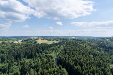 Parlak mavi gökyüzünün altındaki yemyeşil orman ve tepelerin güzel hava manzarası doğanın sükunetini gözler önüne seriyor..
