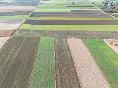 Yamalı tarımsal alanların hava görüntüsü canlı ekin ve arazi renkleri sergiliyor. Doğa severler ve tarım temaları için mükemmel.