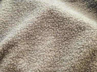 Sıcak kahverengi tonlarda yumuşak desenli kumaş yakın çekim. Moda veya döşeme tasarımı için ideal.