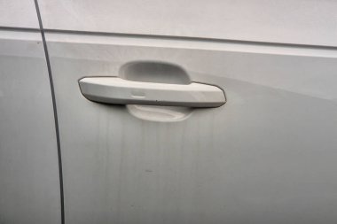 Kirli bir arabanın kapı kolunun kapağı aşınmış ve kirlenmiş. Araç bakımını veya kentsel yaşam tarzını göstermek için mükemmel.