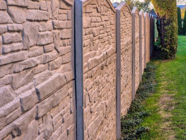 Güzel bir dekoratif taş çit manzarası yemyeşil çimlerin yanında açık alanlar ve peyzaj projeleri için mükemmel..