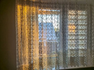 Yumuşak ışık, dantel perdelerden süzülerek sıcak ve davetkar bir atmosfer yaratır. İç dekorasyon için mükemmel bir ilham..