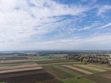 Berrak mavi gökyüzünün altındaki yemyeşil tarım arazilerinin havadan görünüşü kırsal manzaraların güzelliğini gözler önüne seriyor..