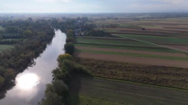 Güneş ışığını yansıtan bir nehrin hava perspektifi, parlak bir parıltı efekti yaratır..