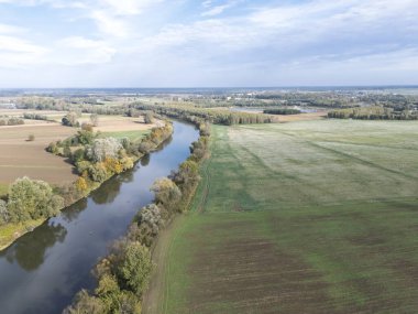 Yeşil tarlalar ve ormanlardan akan sakin bir nehrin havadan görünüşü doğanın ve tarımın güzelliğini gözler önüne seriyor.