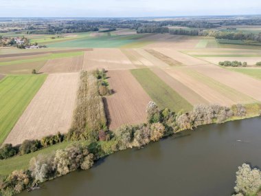 Bereketli yeşil tarlalar ve sakin nehir manzarası kırsal manzaranın güzelliğini gözler önüne seriyor.