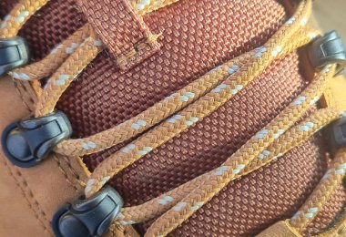 Ayrıntılı bağlama ve doku içeren bir yürüyüş ayakkabısının dayanıklılığını ve dış tasarımı vurguluyor.