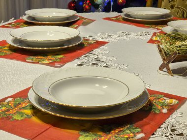 Güzel bir yemek masası zarif tabaklar ve Noel arifesi yemeği için şenlikli masa süslemeleri.