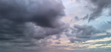 Gün batımında karanlık ve aydınlık bulutlarla dramatik bir gökyüzü büyüleyici bir atmosfer ve hava yaratıyor. Özgeçmiş veya doğa temalı projeler için ideal.