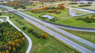 Doğanın güzelliğini ve iyi korunmuş altyapısını gözler önüne seren canlı sonbahar yeşillikleriyle çevrili manzaralı bir otoyol..
