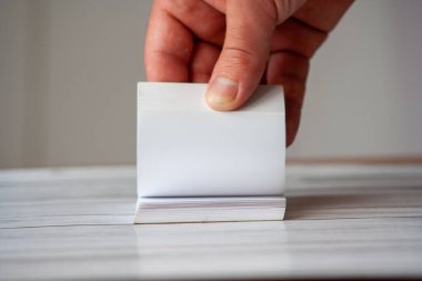 Bir insanın eli boş bir not defterine takla atarak yaratıcılık ve verimlilik sergiliyor. Beyin fırtınası ve planlama kavramları için ideal..