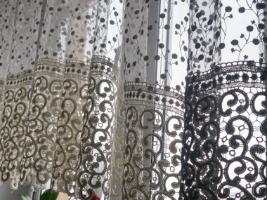 Zarif dantel perdeler nazikçe pencereden sarkıyor sıcak bir iç mekanda narin ve havadar bir atmosfer yaratıyor.