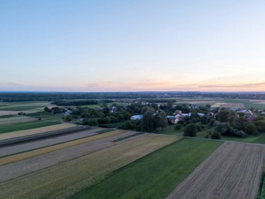 Gün batımında kırsal alanların havadan görünüşü canlı renkler ve sakin manzaralar yakalıyor. Huzurlu bir kırsal bölge rahatlatıcı bir atmosfer sunuyor.