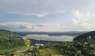 Polonya 'daki Solina Barajı' nın panoramik görüntüsü gölün nefes kesici manzarasını ve parlak gökyüzünün altındaki tepeleri gösteriyor..