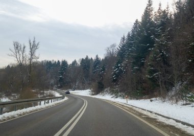 Karla kaplı ağaçlar ve sakin bir manzarayla çevrili manzaralı bir kış yolu. Doğa aşıkları ve seyahat meraklıları için mükemmel..