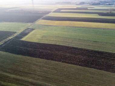 Değişen yeşil ve kahverengi tonlarıyla canlı tarım alanlarının havadan görünüşü kırsal bölgenin güzelliğini gözler önüne seriyor..