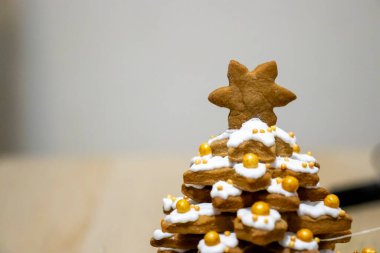 Beyaz krema ve altın boncuklarla süslenmiş zencefilli kurabiye ağacı. Bayram kutlamaları için mükemmel bir ziyafet..