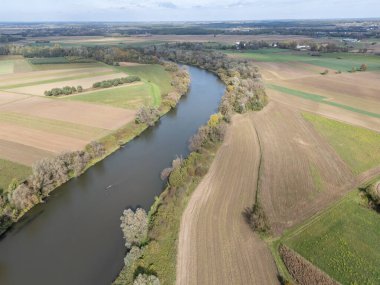 Yeşil tarlalar ve tarım arazileriyle çevrili dolambaçlı bir nehrin havadan görünüşü doğanın güzelliğini gözler önüne seriyor.
