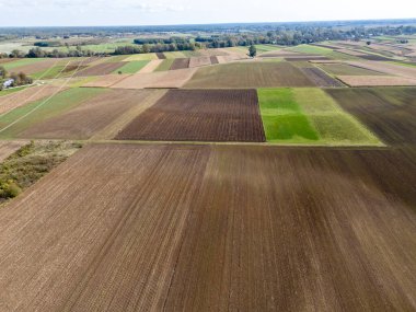 Yamalı tarımsal alanların hava görüntüsü kırsal alanda canlı renklerde ve dokularda çeşitli ürünleri sergiliyor.